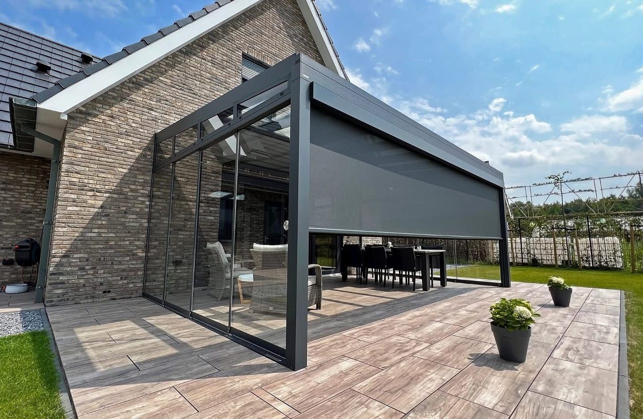 Veranda met verticale screen en glazen schuifwanden op een terras met houtlooktegels